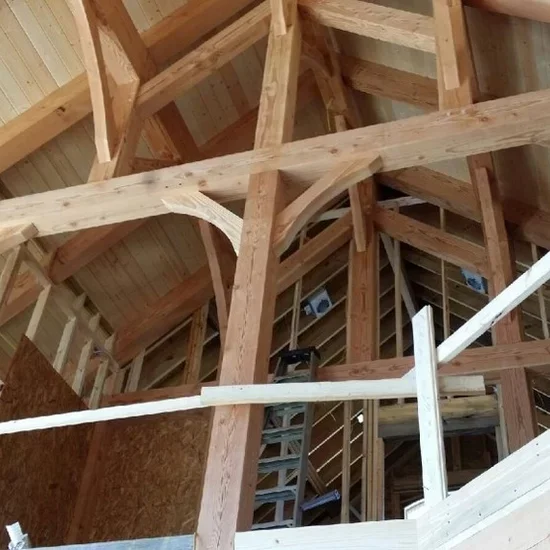 Exposed timber framing with curved beams and structural posts during home construction
