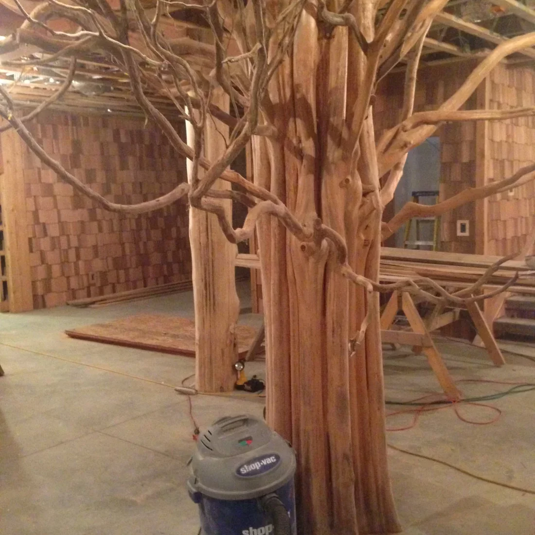 Wooden tree sculpture with carved branches and textured bark in construction phase